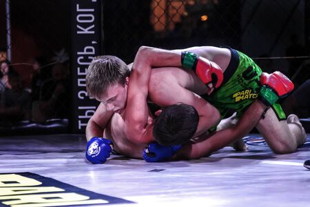 ODESSA, UKRAINE-June 30, 2019: Fighters of MMA boxers are fighting without rules in cage ring of octagons. MMA fighters in ring at championship. Look at boxing fights without rules through metal cageのeditorial素材