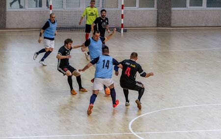 ODESSA, UKRAINE December 15, 2019: Unidentified local team players play futsal futsal tournament on the parquet floor. The right moment of a sports soccer game in an indoor hall, indoor soccerのeditorial素材