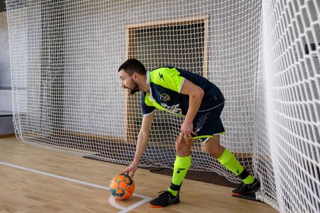 ODESSA, UKRAINE - CIRKA, 202020: Unidentified local team players play futsal futsal tournament on the parquet floor. The right moment of a sports soccer game in an indoor hall, indoor soccerのeditorial素材