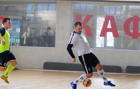 ODESSA, UKRAINE - CIRKA, 202020: Unidentified local team players play futsal futsal tournament on the parquet floor. The right moment of a sports soccer game in an indoor hall, indoor soccerのeditorial素材