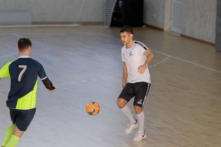 ODESSA, UKRAINE - CIRKA, 202020: Unidentified local team players play futsal futsal tournament on the parquet floor. The right moment of a sports soccer game in an indoor hall, indoor soccerのeditorial素材