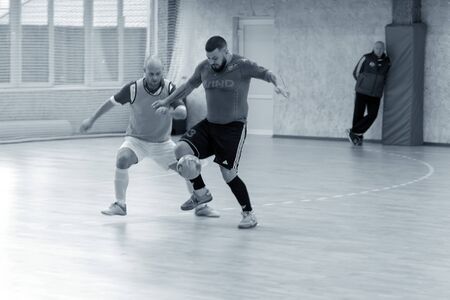 ODESSA, UKRAINE - CIRKA, 202020: Unidentified local team players play futsal futsal tournament on the parquet floor. The right moment of a sports soccer game in an indoor hall, indoor soccerのeditorial素材