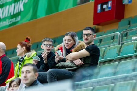 ODESSA, UKRAINA - CIRKA, 2020: Spectators in stands of gym during game of their favorite teams. Sports fans and spectators in stadium racks emotionally support their teamのeditorial素材