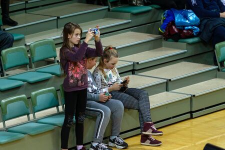 ODESSA, UKRAINA - CIRKA, 2020: Spectators in stands of gym during game of their favorite teams. Sports fans and spectators in stadium racks emotionally support their teamのeditorial素材
