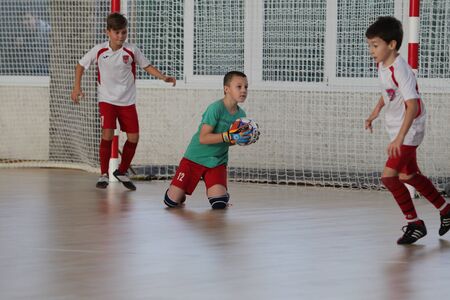 Odessa, Ukraine-December 12, 2019: Little boys, children play mini football in sports hall at sports city Junior championship. Children's sport is healthy lifestyle. Sports children football playersのeditorial素材