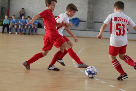 Odessa, Ukraine-December 12, 2019: Little boys, children play mini football in sports hall at sports city Junior championship. Children's sport is healthy lifestyle. Sports children football playersのeditorial素材