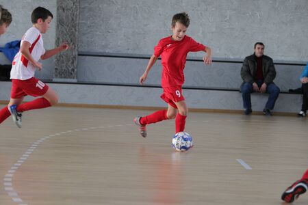 Odessa, Ukraine-December 12, 2019: Little boys, children play mini football in sports hall at sports city Junior championship. Children's sport is healthy lifestyle. Sports children football playersのeditorial素材