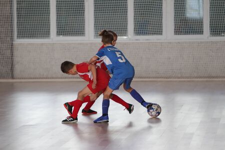 Odessa, Ukraine-December 12, 2019: Little boys, children play mini football in sports hall at sports city Junior championship. Children's sport is healthy lifestyle. Sports children football playersのeditorial素材