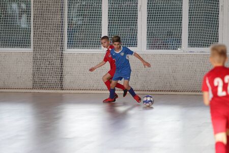Odessa, Ukraine-December 12, 2019: Little boys, children play mini football in sports hall at sports city Junior championship. Children's sport is healthy lifestyle. Sports children football playersのeditorial素材