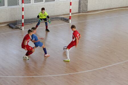 Odessa, Ukraine-December 12, 2019: Little boys, children play mini football in sports hall at sports city Junior championship. Children's sport is healthy lifestyle. Sports children football playersのeditorial素材