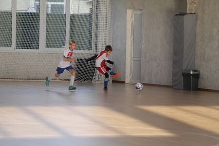 Odessa, Ukraine-December 12, 2019: Little boys, children play mini football in sports hall at sports city Junior championship. Children's sport is healthy lifestyle. Sports children football playersのeditorial素材