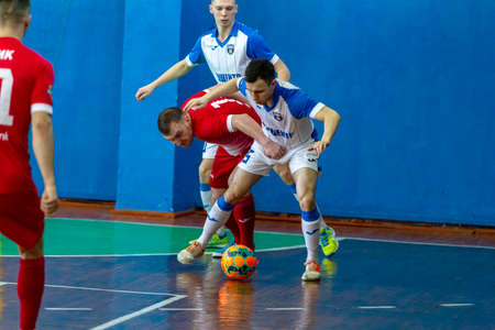 ODESSA, UKRAINE - CIRKA, 2020: domestic football. Footballers of local team play futsal mini-tournament. Acute tense moment of sports soccer match in an indoor hallのeditorial素材