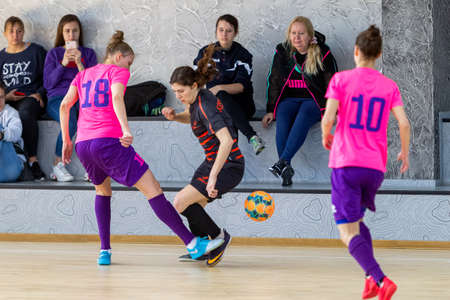 ODESSA, UKRAINE - March 13, 2020: Futsal Cup of Ukraine, futsal among students. During final match in futsal among student teams. Beautiful sports girls play mini football on parquet floorのeditorial素材