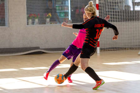 ODESSA, UKRAINE - March 13, 2020: Futsal Cup of Ukraine, futsal among students. During final match in futsal among student teams. Beautiful sports girls play mini football on parquet floorのeditorial素材