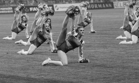 ODESSA, UKRAINE - July28, 2019: Performance of beautiful young girls cheerleader team during opening of football championship. Team performance cheerleader on grass field stadium. Girls of cheerleaderのeditorial素材