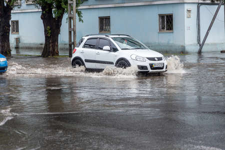 Odessa, Ukraine - May 28, 2020: driving car on flooded road during flood caused by torrential rains....