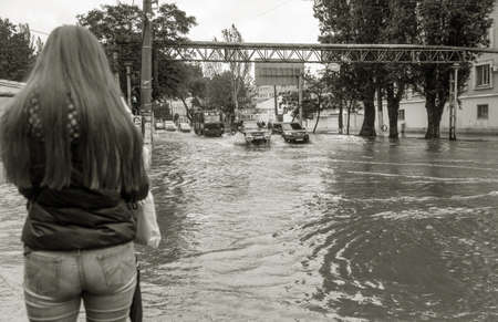 Odessa, Ukraine - May 28, 2020: driving car on flooded road during flood caused by torrential rains. Cars float on water, flooding streets. Splash on car. Flooded city road with large puddleのeditorial素材