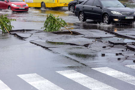 Odessa, Ukraine - May 28, 2020: driving car on flooded road during flood caused by torrential rains. Cars float on water, flooding streets. Splash on car. Flooded city road with large puddleのeditorial素材