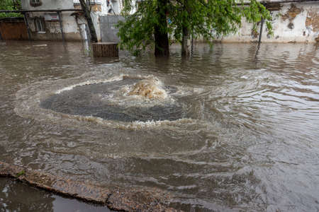 Odessa, Ukraine - May 28, 2020: driving car on flooded road during flood caused by torrential rains. Cars float on water, flooding streets. Splash on car. Flooded city road with large puddleのeditorial素材