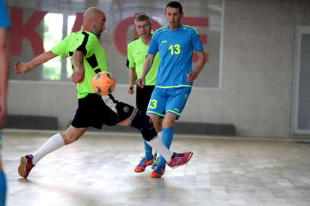 Odessa, Ukraine- May 29, 2020: Cup playoff match match in futsal among veterans 50+. Futsal on large stage of sports hall, covering modern playground. Intense game of mini football in hall. On parquetのeditorial素材