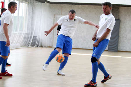 Odessa, Ukraine- May 29, 2020: Cup playoff match match in futsal among veterans 50+. Futsal on large stage of sports hall, covering modern playground. Intense game of mini football in hall. On parquetのeditorial素材