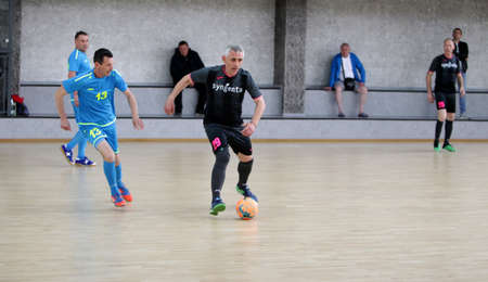 Odessa, Ukraine- May 29, 2020: Cup playoff match match in futsal among veterans 50+. Futsal on large stage of sports hall, covering modern playground. Intense game of mini football in hall. On parquetのeditorial素材