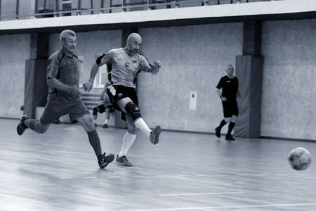 Odessa, Ukraine- May 29, 2020: Cup playoff match match in futsal among veterans 50+. Futsal on large stage of sports hall, covering modern playground. Intense game of mini football in hall. On parquetのeditorial素材