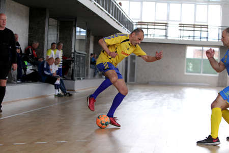 Odessa, Ukraine- May 29, 2020: Cup playoff match match in futsal among veterans 50+. Futsal on large stage of sports hall, covering modern playground. Intense game of mini football in hall. On parquetのeditorial素材