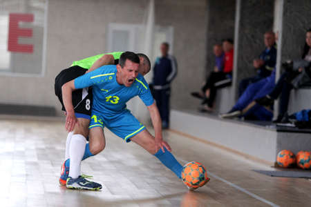 Odessa, Ukraine- May 29, 2020: Cup playoff match match in futsal among veterans 50+. Futsal on large stage of sports hall, covering modern playground. Intense game of mini football in hall. On parquetのeditorial素材