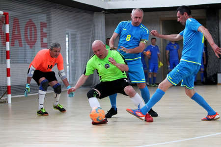 Odessa, Ukraine- May 29, 2020: Cup playoff match match in futsal among veterans 50+. Futsal on large stage of sports hall, covering modern playground. Intense game of mini football in hall. On parquetのeditorial素材