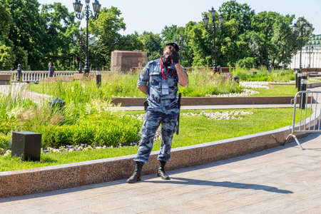Young soldier of Russia Guard wearing summer camouflage, protective mask and gloves working on the...