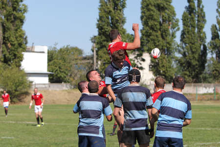 ODESSA, UKRAINE - SEPTEMBER 12, 2020: Final games of strongest rugby-7 teams in Ukrainian championship. Rugby ball on field. Rugby match is tough fight for ball. Athletes team players on fieldのeditorial素材