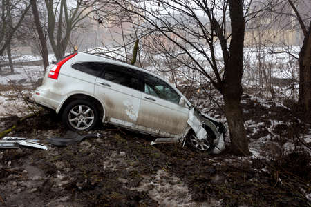 Odessa, Ukraine-1 Feb 2021: Traffic accident. Car drove off slippery winter road during heavy fog. Broken car after an accident in roadside ditch. Driver coped with control of the car in fog and iceのeditorial素材