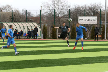 Odessa, Ukraine - March 19, 2021: Local amateur football teams of the second league play in championship on the artificial grass of stadium. Football on field with artificial grass for soccer gamesのeditorial素材
