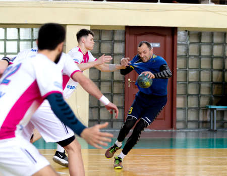 ODESSA, UKRAINE - April 23, 2021: Handball. Federation of Men's Handball of Ukraine. Match Odessa - Motor Sich, Zaporozhye - white. Action during men's handball game. Hard attacking with ballのeditorial素材