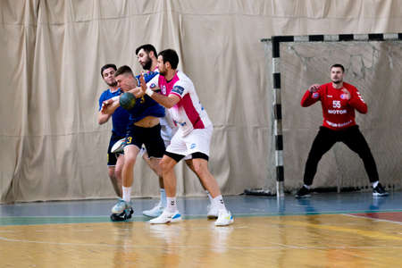 ODESSA, UKRAINE - April 23, 2021: Handball. Federation of Men's Handball of Ukraine. Match Odessa - Motor Sich, Zaporozhye - white. Action during men's handball game. Hard attacking with ballのeditorial素材