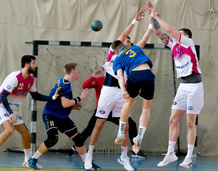 ODESSA, UKRAINE - April 23, 2021: Handball. Federation of Men's Handball of Ukraine. Match Odessa - Motor Sich, Zaporozhye - white. Action during men's handball game. Hard attacking with ballのeditorial素材
