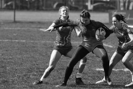 ODESSA, UKRAINE -17 April 2021: Cup of Ukraine among women's rugby teams 7. Odessa - blue, Kiev Aviator - orange. Tense moment of women's rugby match. Dramatic challenging game for women's rugby teamのeditorial素材