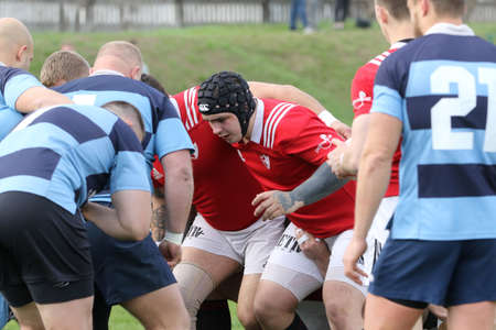 ODESSA, UKRAINE - April 17, 2021: Rugby Cup 7. Odessa Polytechnic Derby - blue, CREDO - red. Tense moment of men's rugby match. Dramatic and challenging men's rugby derby. Men fight on rugby fieldのeditorial素材