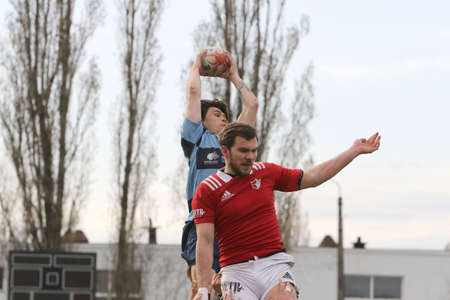 ODESSA, UKRAINE - April 17, 2021: Rugby Cup 7. Odessa Polytechnic Derby - blue, CREDO - red. Tense moment of men's rugby match. Dramatic and challenging men's rugby derby. Men fight on rugby fieldのeditorial素材