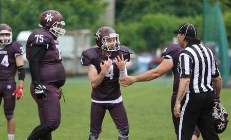 ODESSA, UKRAINE - May 30, 2021: American football on the grass. A tough duel, a battle between Odessa REINGERS and Nikolaev VIKINGS on the wet lawn of stadium. Tough American Football Athletes Battleのeditorial素材