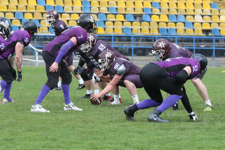 ODESSA, UKRAINE - May 30, 2021: American football on the grass. A tough duel, a battle between Odessa REINGERS and Nikolaev VIKINGS on the wet lawn of stadium. Tough American Football Athletes Battleのeditorial素材