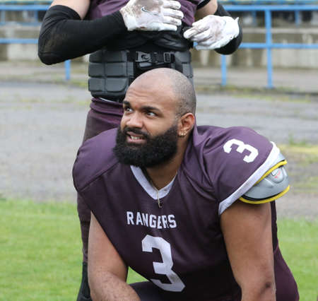 ODESSA, UKRAINE - May 30, 2021: American football on the grass. A tough duel, a battle between Odessa REINGERS and Nikolaev VIKINGS on the wet lawn of stadium. Tough American Football Athletes Battleのeditorial素材
