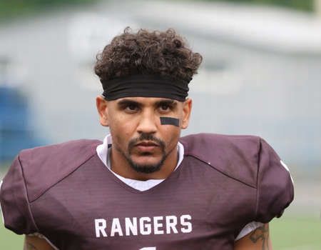 ODESSA, UKRAINE - May 30, 2021: American football on the grass. A tough duel, a battle between Odessa REINGERS and Nikolaev VIKINGS on the wet lawn of stadium. Tough American Football Athletes Battleのeditorial素材