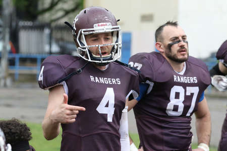 ODESSA, UKRAINE - May 30, 2021: American football on the grass. A tough duel, a battle between Odessa REINGERS and Nikolaev VIKINGS on the wet lawn of stadium. Tough American Football Athletes Battleのeditorial素材