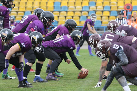ODESSA, UKRAINE - May 30, 2021: American football on the grass. A tough duel, a battle between Odessa REINGERS and Nikolaev VIKINGS on the wet lawn of stadium. Tough American Football Athletes Battleのeditorial素材