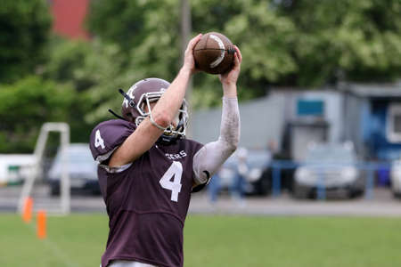 ODESSA, UKRAINE - May 30, 2021: American football on the grass. A tough duel, a battle between Odessa REINGERS and Nikolaev VIKINGS on the wet lawn of stadium. Tough American Football Athletes Battleのeditorial素材
