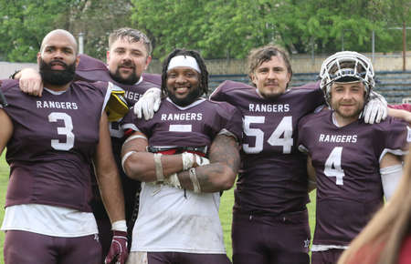 ODESSA, UKRAINE - May 30, 2021: American football on the grass. A tough duel, a battle between Odessa REINGERS and Nikolaev VIKINGS on the wet lawn of stadium. Tough American Football Athletes Battleのeditorial素材