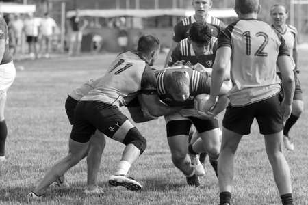 Odessa, Ukraine - June 23, 2021: Odessa National Team CREDO (red) - OLYMP-Kharkiv (yellow) in rugby 7s. Sharp aggressive fight of male rugby players for ball. Dynamic play on green grass of stadiumのeditorial素材