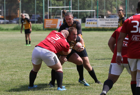 Odessa, Ukraine - June 23, 2021: Odessa National Team CREDO (red) - OLYMP-Kharkiv (yellow) in rugby 7s. Sharp aggressive fight of male rugby players for ball. Dynamic play on green grass of stadiumのeditorial素材